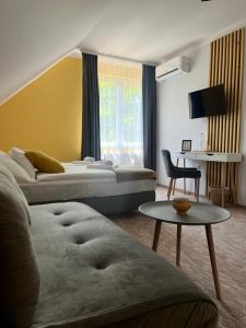 a hotel room with two beds and a table at Aventurin House *** in Révfülöp