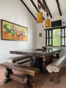 una sala da pranzo con tavolo e panche di CASA CAMPESTRE LA CAMPIÑA LA VICTORIA Valle del Cauca ESPACIO COMPLETO a Matazarza