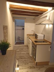 cocina con encimera y microondas en Petra apartments -Old City with terrace and barbecue- en Tarragona