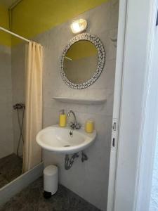 a bathroom with a sink and a mirror at Mini Beach House in Logaras