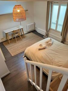a bedroom with a bed and a table and a desk at Superbe appartement avec cheminée in Fontainebleau