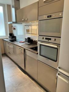 a kitchen with stainless steel appliances in a room at Superbe appartement avec cheminée in Fontainebleau