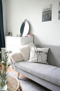 a living room with a couch and a mirror at City Center Coziest Studio in Tampere