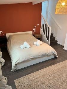 a bedroom with a bed with two towels on it at Superbe appartement avec cheminée in Fontainebleau