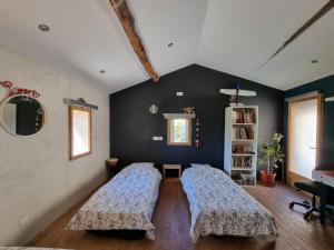 Duas camas num quarto com uma parede preta em Mas Montet chez Raphael em Valleraugue