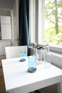 einen weißen Tisch mit zwei Gläsern und Flaschen darauf in der Unterkunft City Center Coziest Studio in Tampere