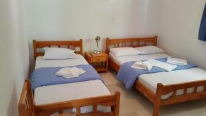 ein Zimmer mit zwei Betten und einem Tisch mit Lampe in der Unterkunft Esperides Hotel in Paralia Agias Foteinis
