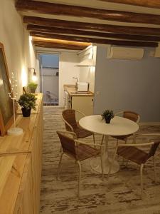 Habitación con mesa, sillas y cocina. en Petra apartments -Old City with terrace and barbecue- en Tarragona