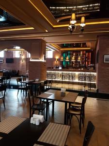 a restaurant with tables and chairs and a bar at ORBI PALACE DeLuxe nice apartment in Bakuriani