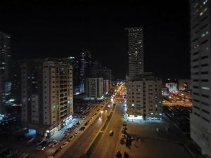 eine Stadtstraße in der Nacht mit Gebäuden und Straßenbeleuchtung in der Unterkunft Khan Property in Schardscha