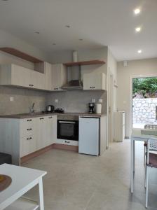 a large kitchen with white appliances and a table at GERAKOFOLIA-VILLA in Nikiana