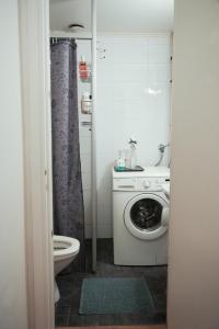 ein Badezimmer mit einer Waschmaschine und einem WC in der Unterkunft City Center Coziest Studio in Tampere