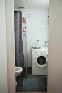 a bathroom with a washing machine and a toilet at City Center Coziest Studio in Tampere