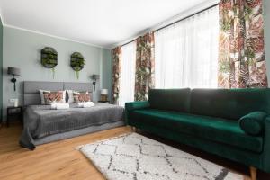 a living room with a green couch and a bed at Mary&Arte Apartments Grzegórzecka 15 in Krakow