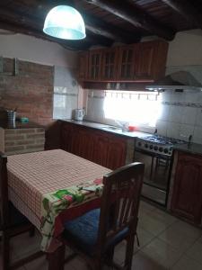 cocina pequeña con mesa y fogones en Casa Las Magdalenas en Merlo