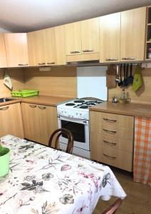 cocina con mesa y horno de fogón blanco en Vukčević apartman, en Sutomore