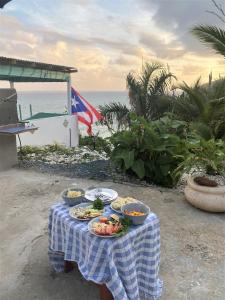 a table with plates of food on it with the ocean at CASA BONITA in Maunabo