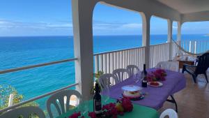 a table on a balcony with a view of the ocean at CASA BONITA in Maunabo