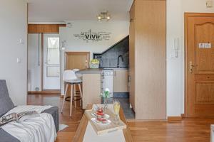 eine Küche und ein Wohnzimmer mit einem Sofa und einem Tisch in der Unterkunft San Amaro Beach 1 by TheBlueWaveApartments com in A Coruña