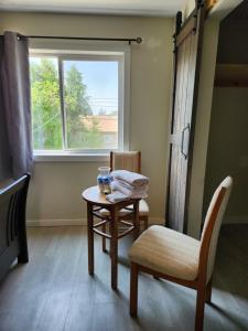 a room with a table and a chair and a window at Elmwood stay in Winnipeg