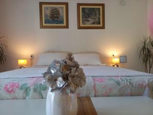 ein Schlafzimmer mit einem Bett und einer Vase mit Blumen darin in der Unterkunft App Ruzica in Crikvenica