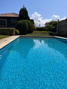 a large blue swimming pool in front of a house at Chalet Playa América. in Nigrán