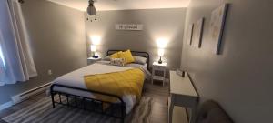 a small bedroom with a bed with a yellow blanket at Lush's Lodge in Cormack