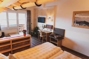 a bedroom with a bed and a desk and a table at Berghotel Sonnenklause in Sonthofen