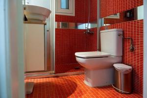een rood betegelde badkamer met een toilet en een wastafel bij Casa miranda in Athene