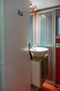 een badkamer met een witte wastafel en een douche bij Casa miranda in Athene