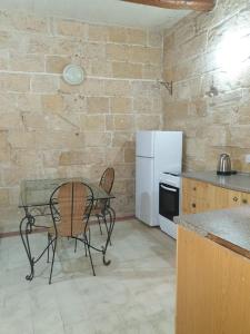 uma cozinha com uma mesa e um frigorífico branco em Tifkira (The Memory) em Birgu