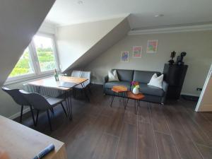 ein Wohnzimmer mit einem Sofa und einem Tisch in der Unterkunft Neumühler Hof - moderne Ferienwohnung "Janica" mit ruhiger Lage zum Garten raus mit kostenfreien Wlan und Netflix in Schwerin