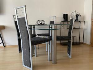 a dining room table with black chairs and a mirror at Ferienwohnung mit Terrasse Nähe Bayreuth in Heinersreuth