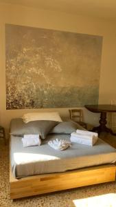 un letto in una stanza con un dipinto sul muro di Appartamenti vacanze Marina di bibbona a Marina di Bibbona