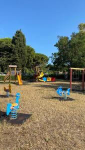 un parco giochi con sedie blu di plastica di Appartamenti vacanze Marina di bibbona a Marina di Bibbona