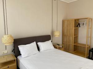 a bedroom with a bed with white sheets and two pillows at Erato Apartments in Petalidi