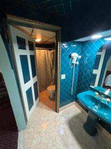 a bathroom with a blue sink and a mirror at Royal Inn - Neptune in Neptune City