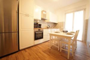 a kitchen with a table with chairs and a refrigerator at Attico tra cielo e mare in Moneglia
