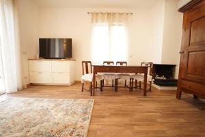 a living room with a table and a flat screen tv at Attico tra cielo e mare in Moneglia