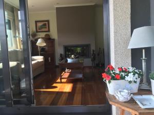a living room with a table with a vase of flowers at Chalet Playa América. in Nigrán