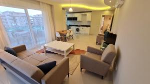 a living room with a couch and chairs and a table at Kleopatra Carina Apart in Alanya