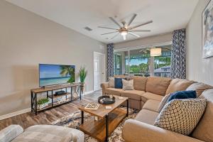 uma sala de estar com um sofá e uma televisão de ecrã plano em Golf Condo- Resort Pool- LakeView- 10mi to beaches em Naples