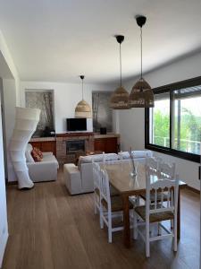 a living room with a table and chairs and a couch at Casa de campo "La Campanera" in Constantina