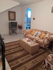 Harqalah的住宿－Maison à Hergla, Sousse, Tunisie，客厅配有沙发和桌子