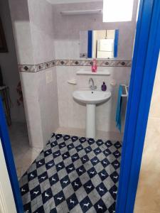 a bathroom with a sink and a black and white checkered floor at Maison à Hergla, Sousse, Tunisie in Harqalah