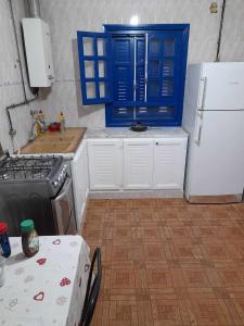 eine Küche mit einer Spüle, einem Kühlschrank und einem Tisch in der Unterkunft Maison à Hergla, Sousse, Tunisie in Harqalah