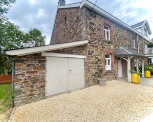 a brick house with a white garage at Le Sartisfait in Jalhay
