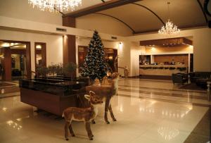 a christmas tree and a deer in a lobby at Valis Resort Hotel in Volos