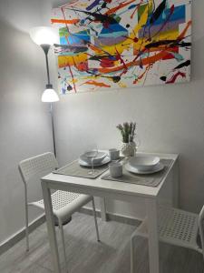 a dining room table with a painting on the wall at Urban Lodgings One @ Roosevelt 457 in San Juan