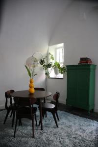 a dining room with a table and chairs and a green cabinet at Philipse Suite in Nijmegen